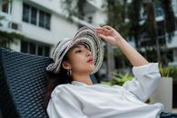 一位戴着别致草帽的女子正在热带度假胜地享受休闲时光