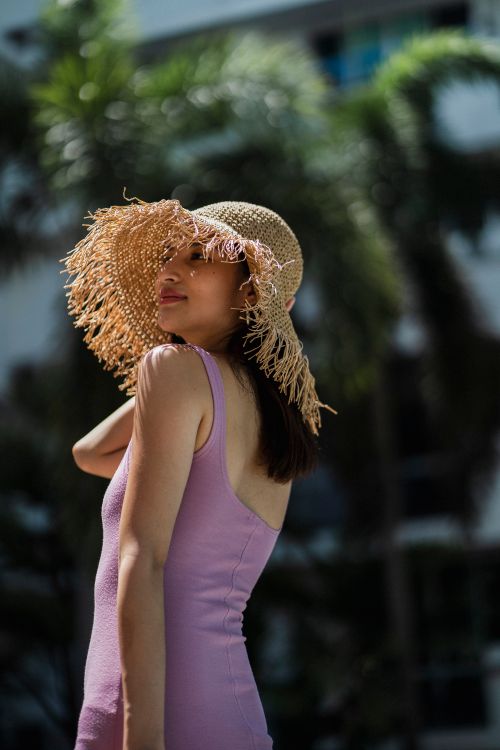 Free Side view of young slim content Asian female tourist in stylish straw hat and swimsuit enjoying summer sunny day in tropical resort Stock Photo
