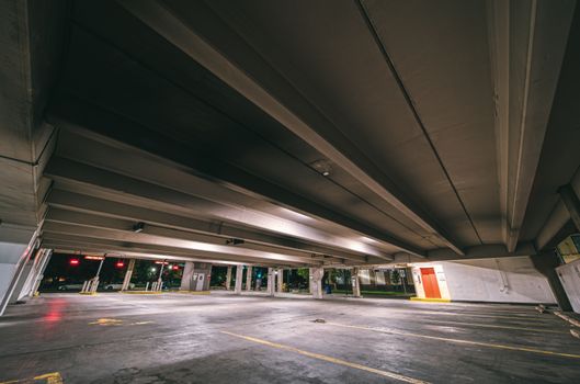 地下停车场入口处，夜间混凝土屋顶下有停车位