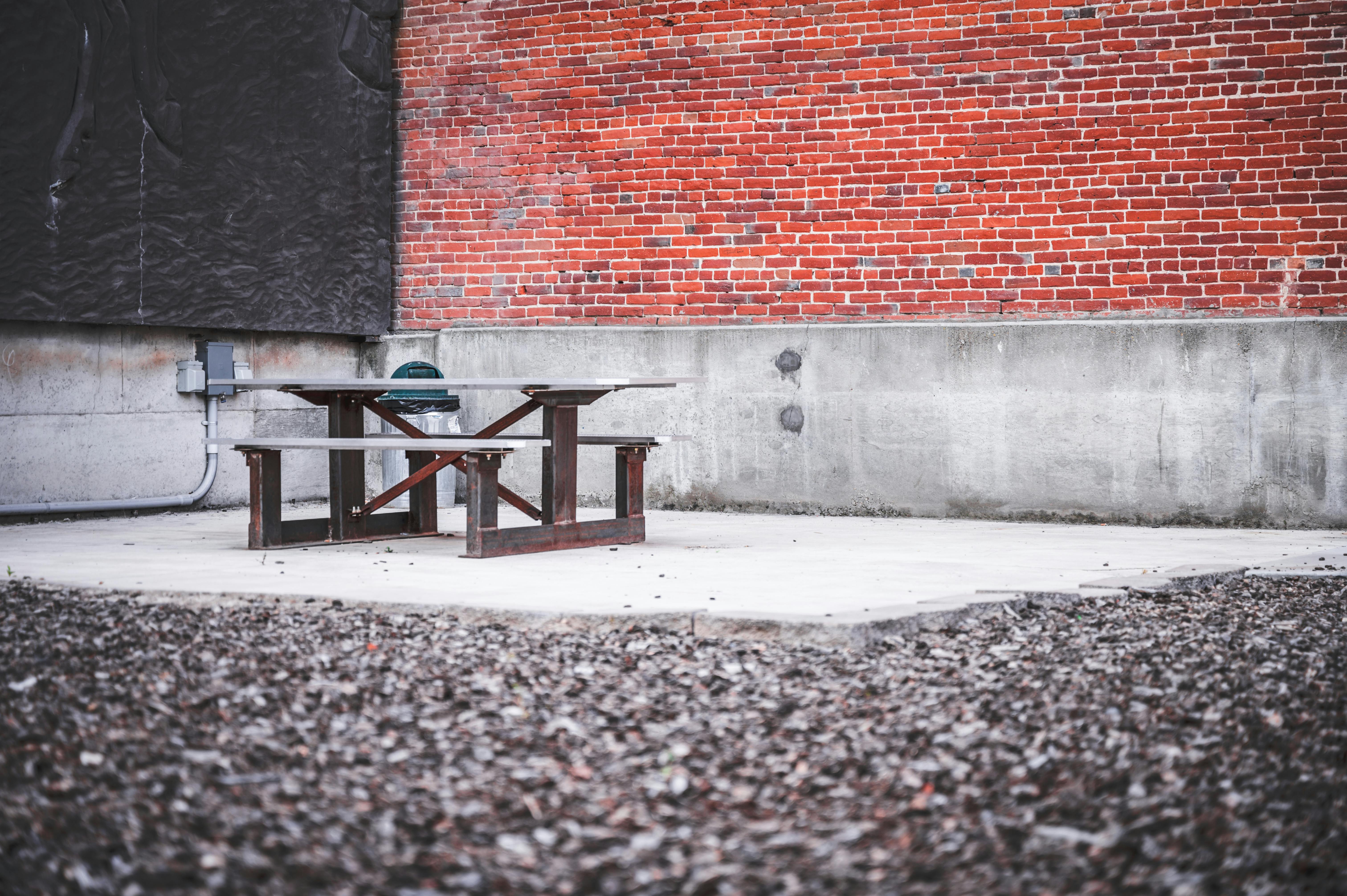 Free Corner of aged shabby house with metal empty benches and table located in district Stock Photo