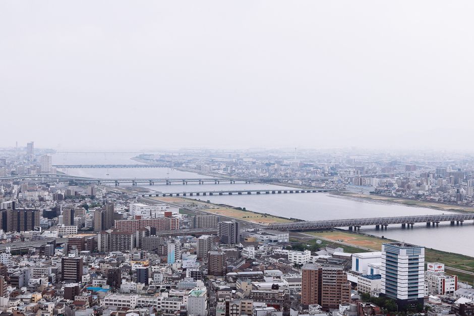 High-angle view of a sprawling city with prominent bridges crossing a wide river.