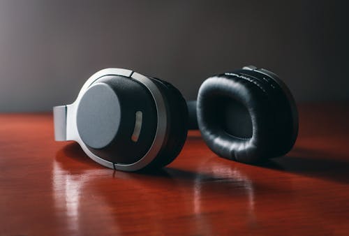 Free Close-Up Shot of Black Headphones on a Wooden Surface Stock Photo