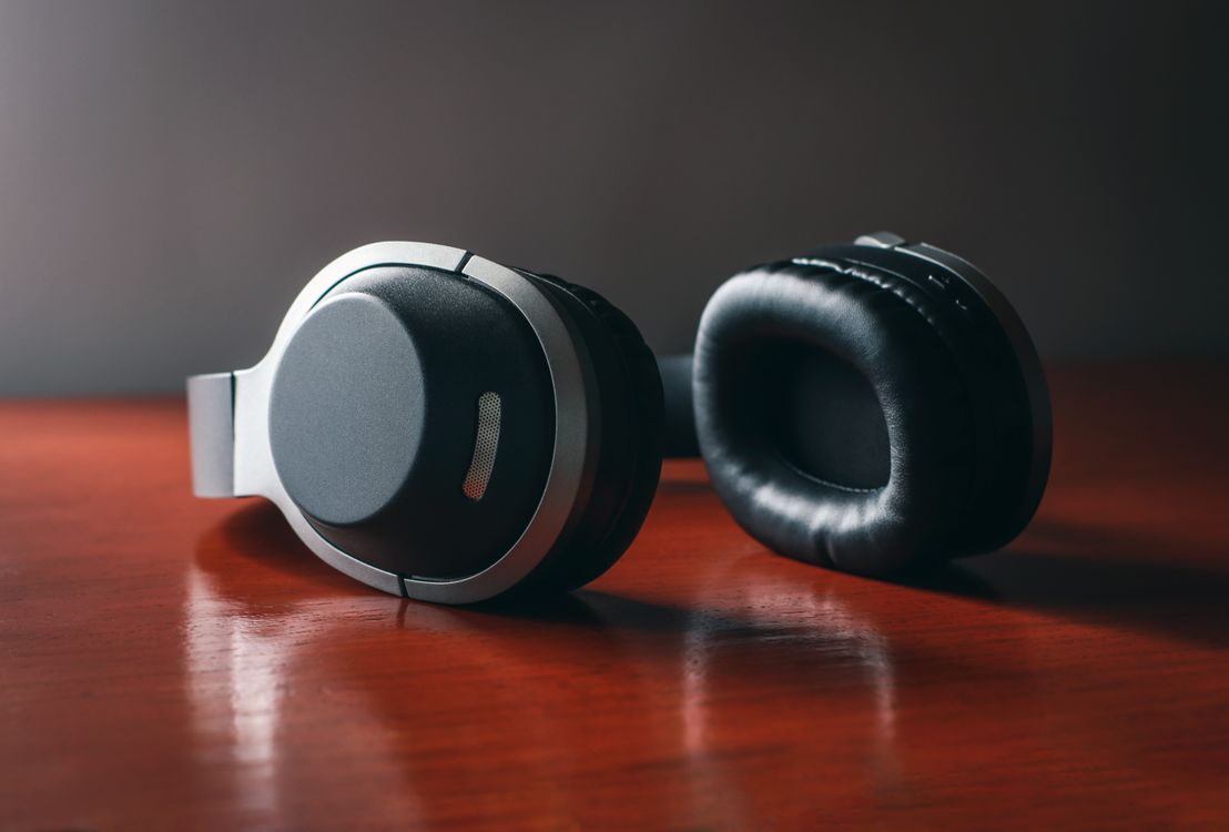 Close-up shot of black headphones on a wooden surface.