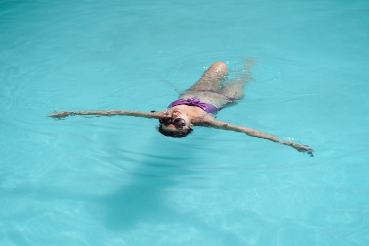 Anonymous Woman Swimming In Outdoor Pool On Sunny Day