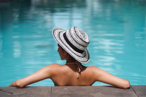 Señora Delgada Anónima Descansando En El Agua De La Piscina Y Mirando A Otro Lado