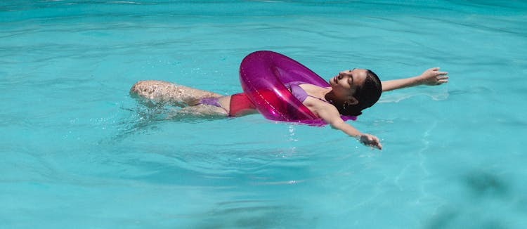 Happy Young Asian Female Swimming In Pool With Lifesaver