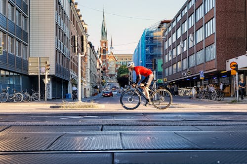 Man in Red Shirt Riding Bicycle on Road