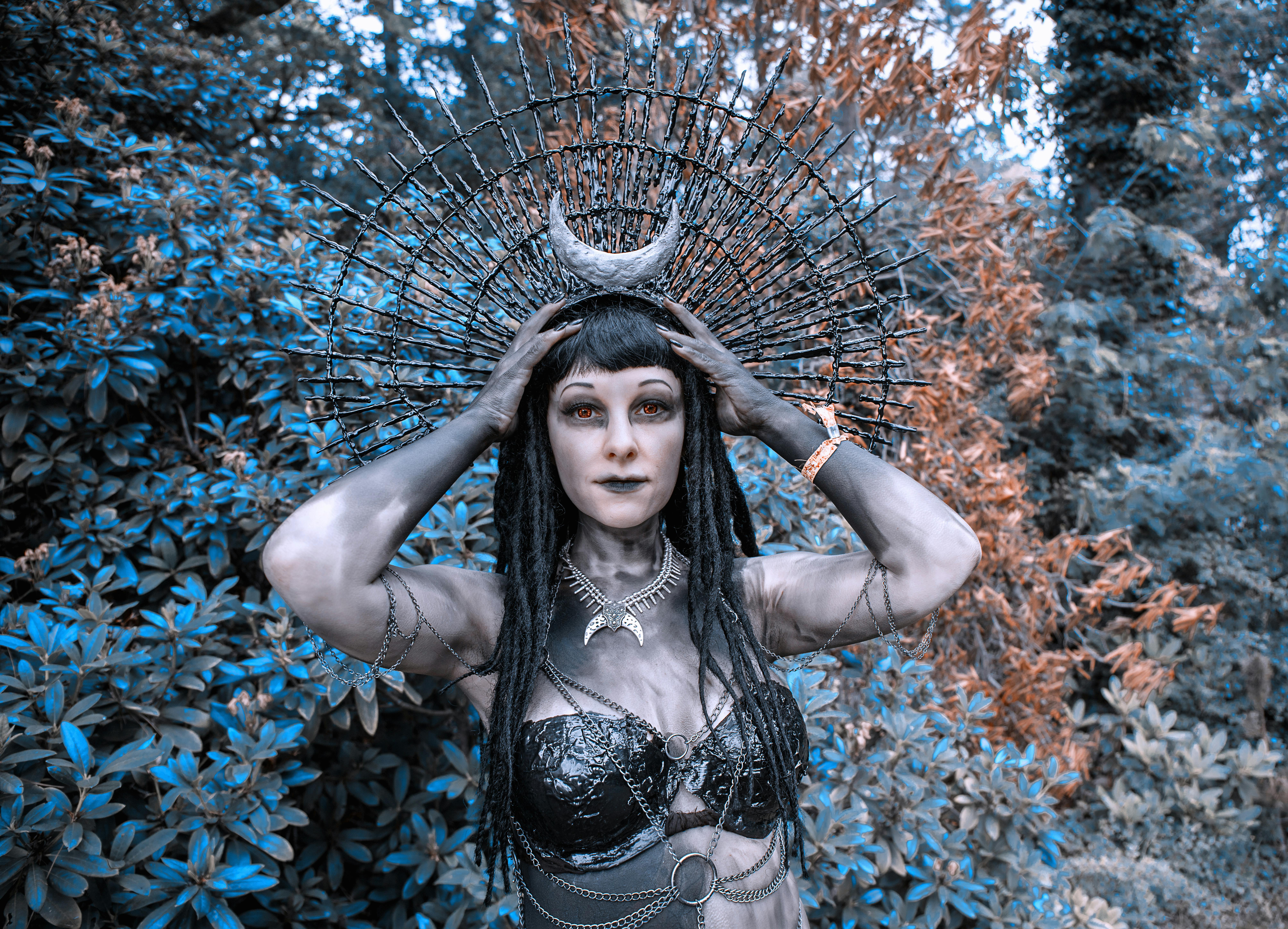 神秘森林中，一位身着精致哥特式服装、头戴月亮头饰的女人