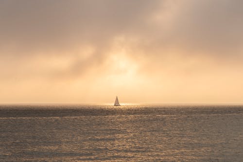 A Sailboat Sailing on the Sea during Sunset