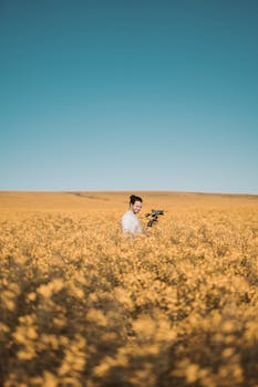 在南非开普敦，一名男子在晴朗的蓝天下，捕捉花田盛开的美丽