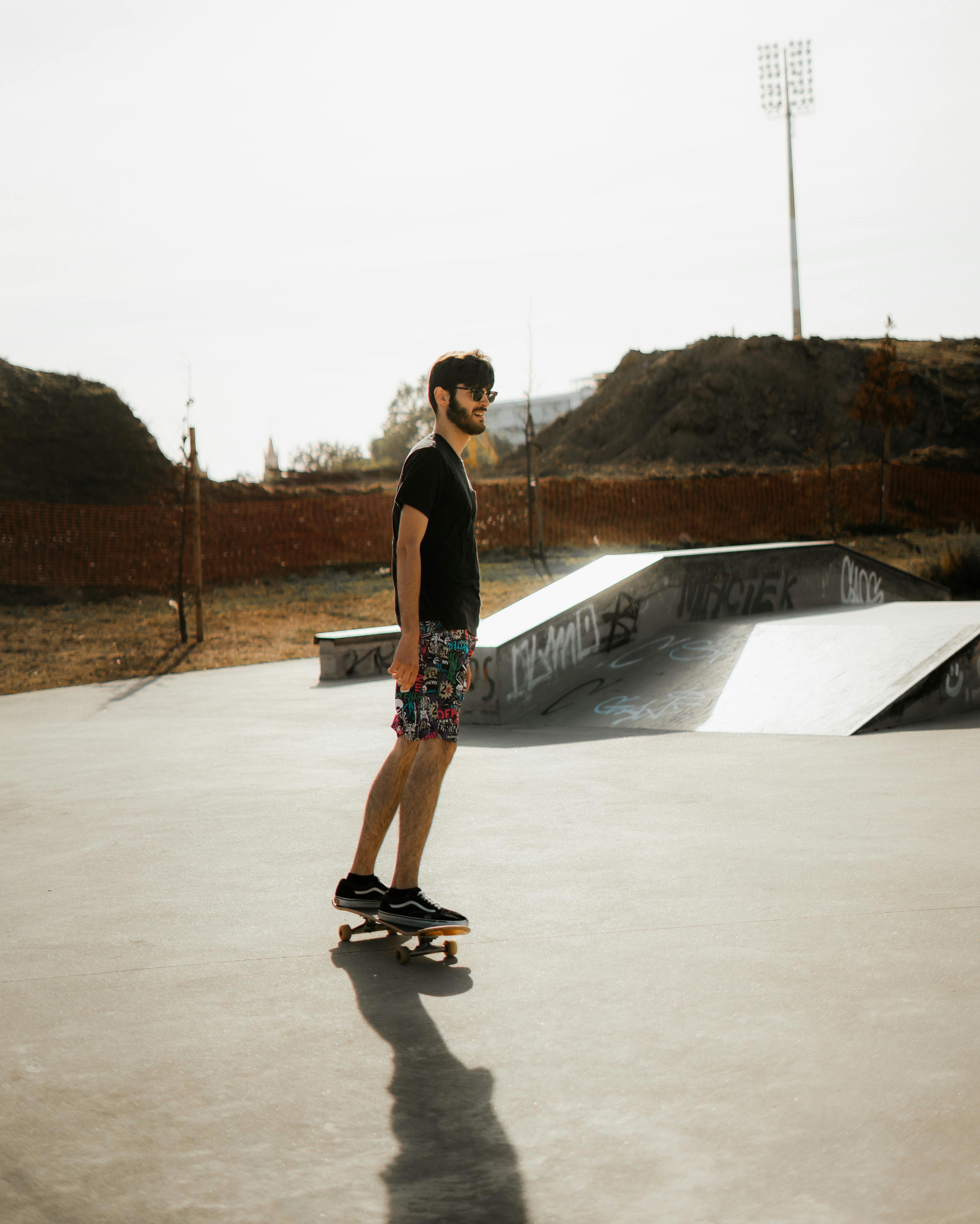 Young man skateboarding in a sunny outdoor skate park, capturing leisure and recreation in Aveiro, Portugal.
