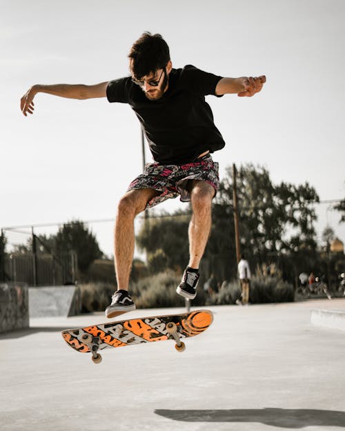 Free Man in Black T-shirt and Shorts Riding Skateboard Stock Photo