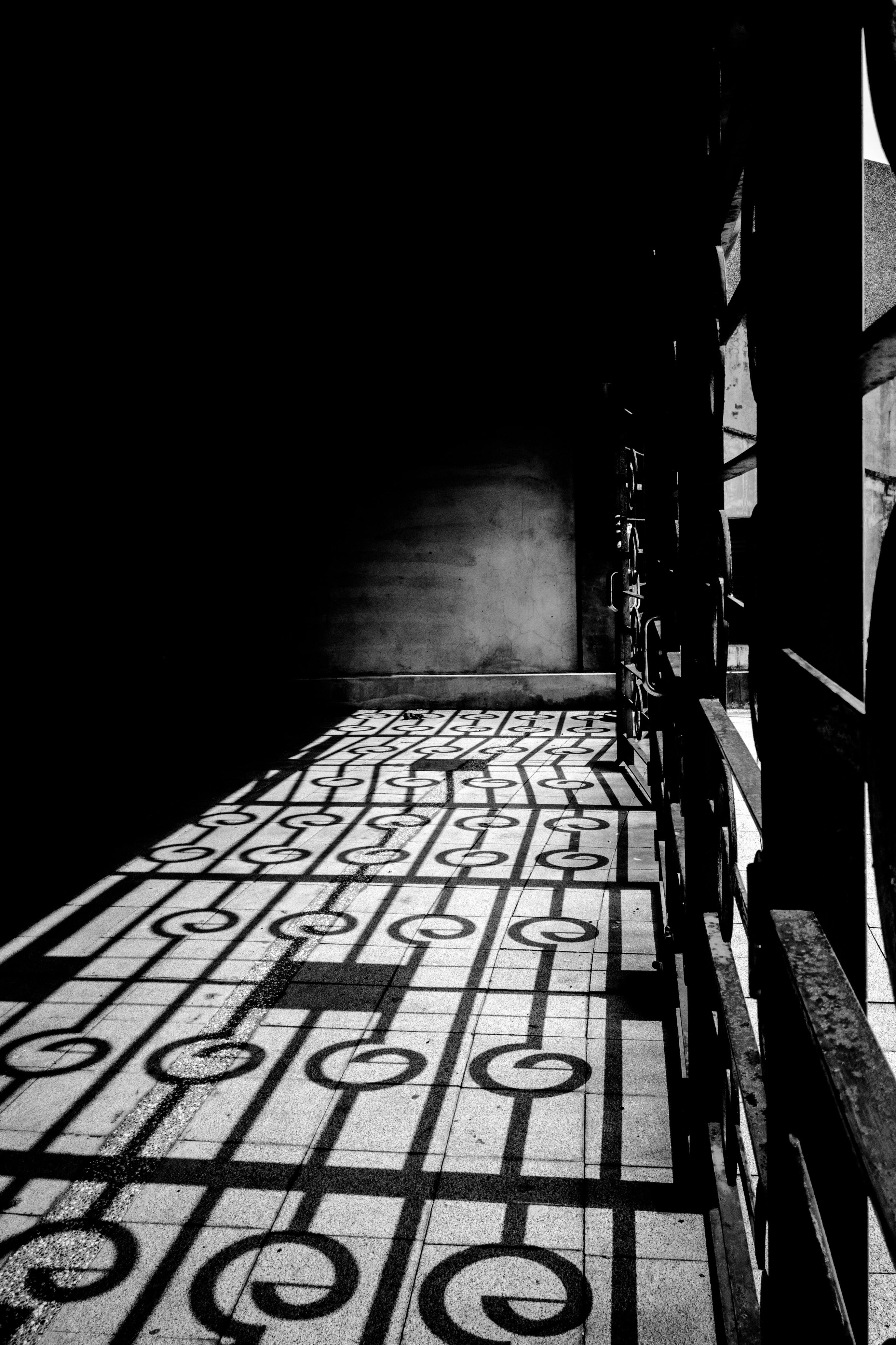 Free Black and white photo capturing geometric shadows on a corridor floor in Taiwan. Strong contrast and patterns. Stock Photo