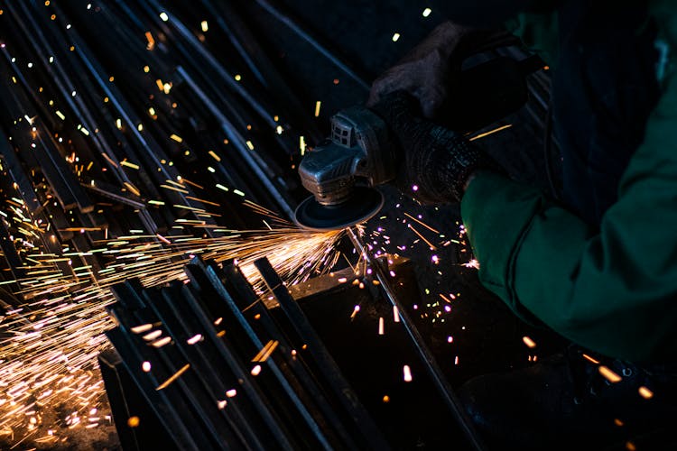 A Person Grinding A Metal