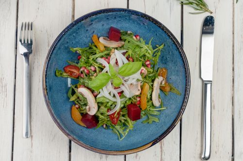 Free A vibrant organic vegetable salad featuring fresh ingredients in a rustic blue bowl, perfect for a healthy meal. Stock Photo