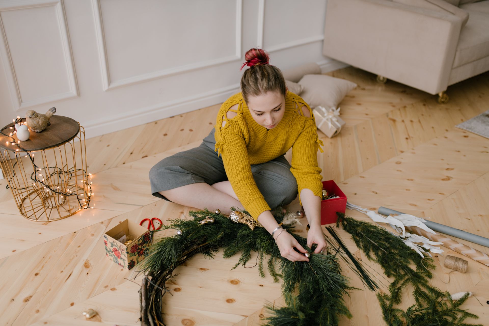 A Woman in Yellow Knitted Sweater Holding a Christmas Wreath