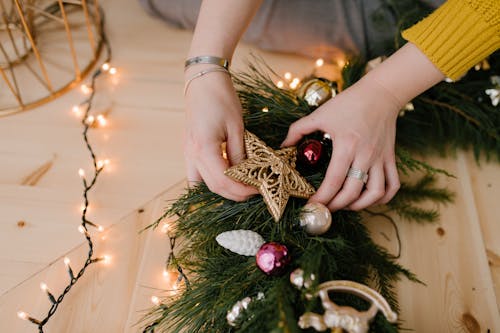 Лицо, занимающее золотое и красное украшение рождественской елки