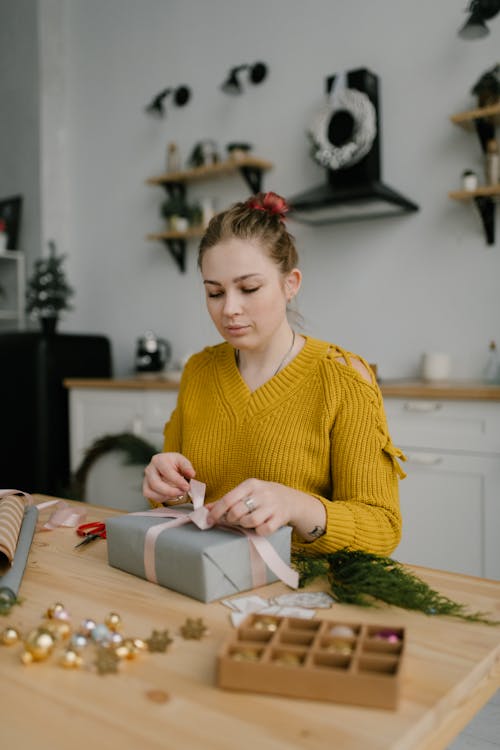 Femme En Pull Jaune Tenant Du Papier Blanc