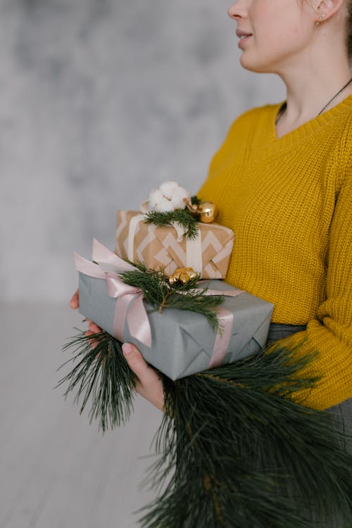 A Woman in Yellow Sweater Holding Gift Boxes