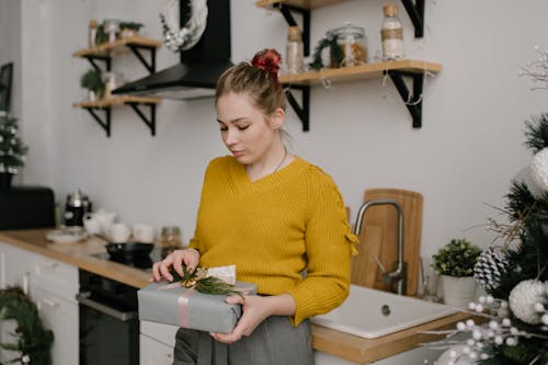 Kobieta Trzyma Zielony Plastikowy Pojemnik W żółtym Swetrze