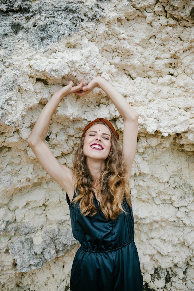 Stylish Cheerful Woman Standing Against Stone Formation