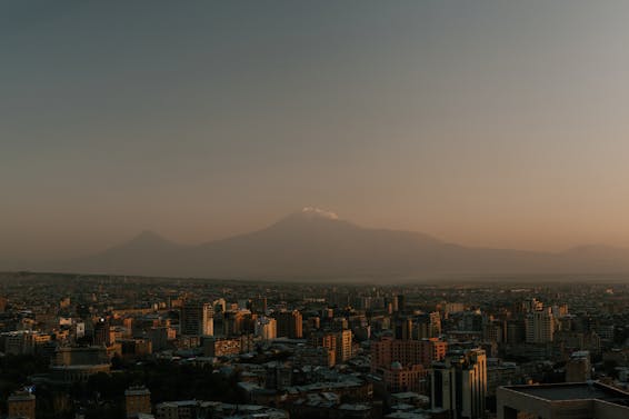 From above of high towers located in city against high rocky top in evening