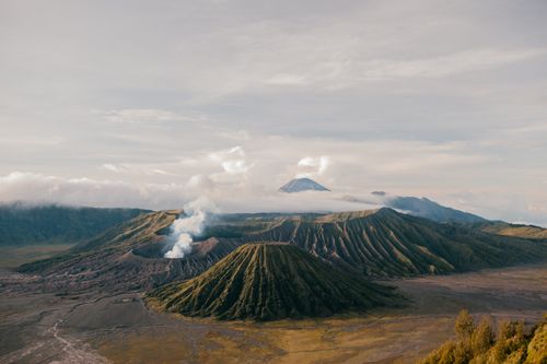 Free From above of picturesque scenery of volcanic mountains located in vast desolate terrain under cloudy sky Stock Photo