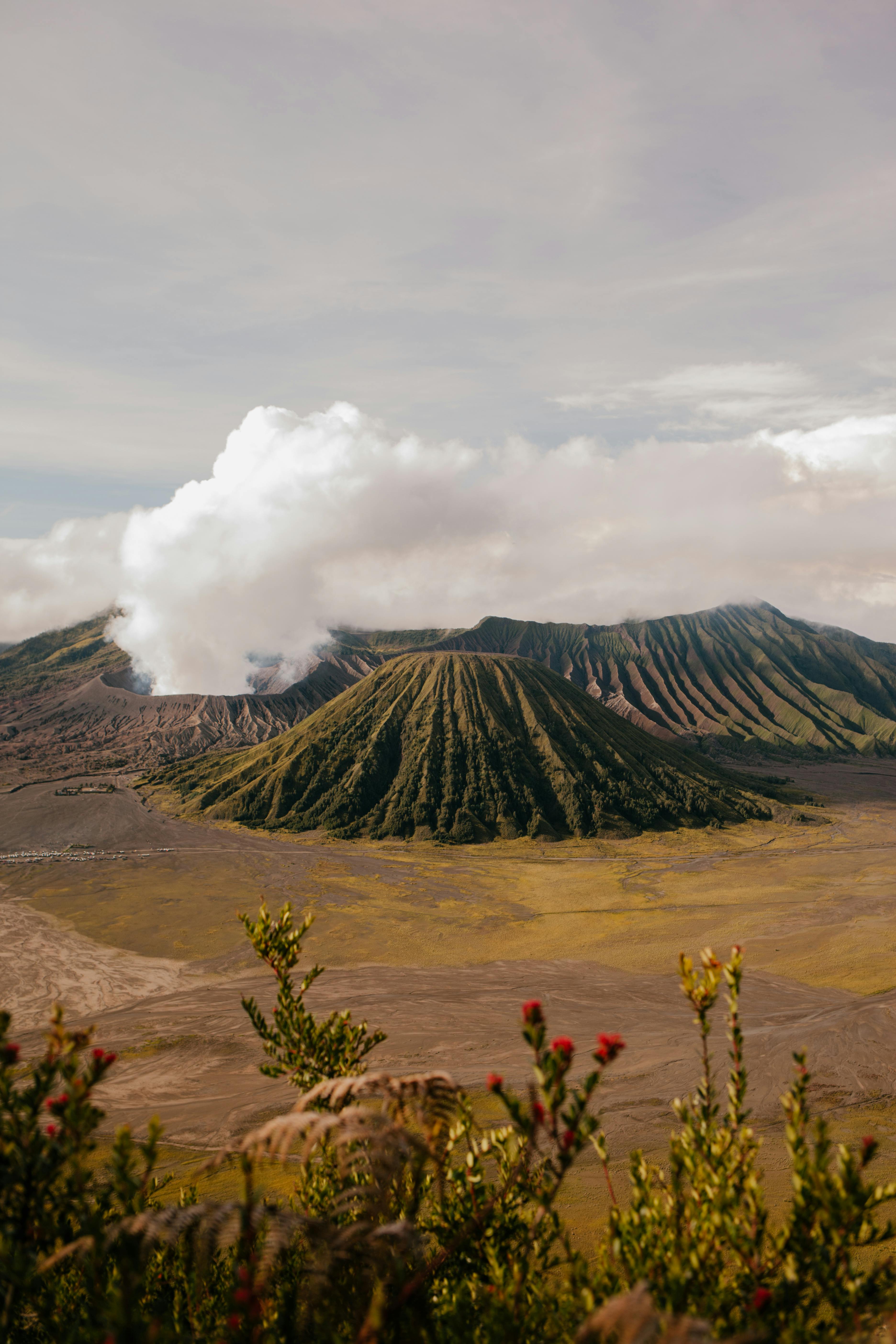 volcanic mountains in desert valley under clouds