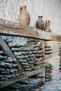 Wooden shelves with dusty glass bottles of wine