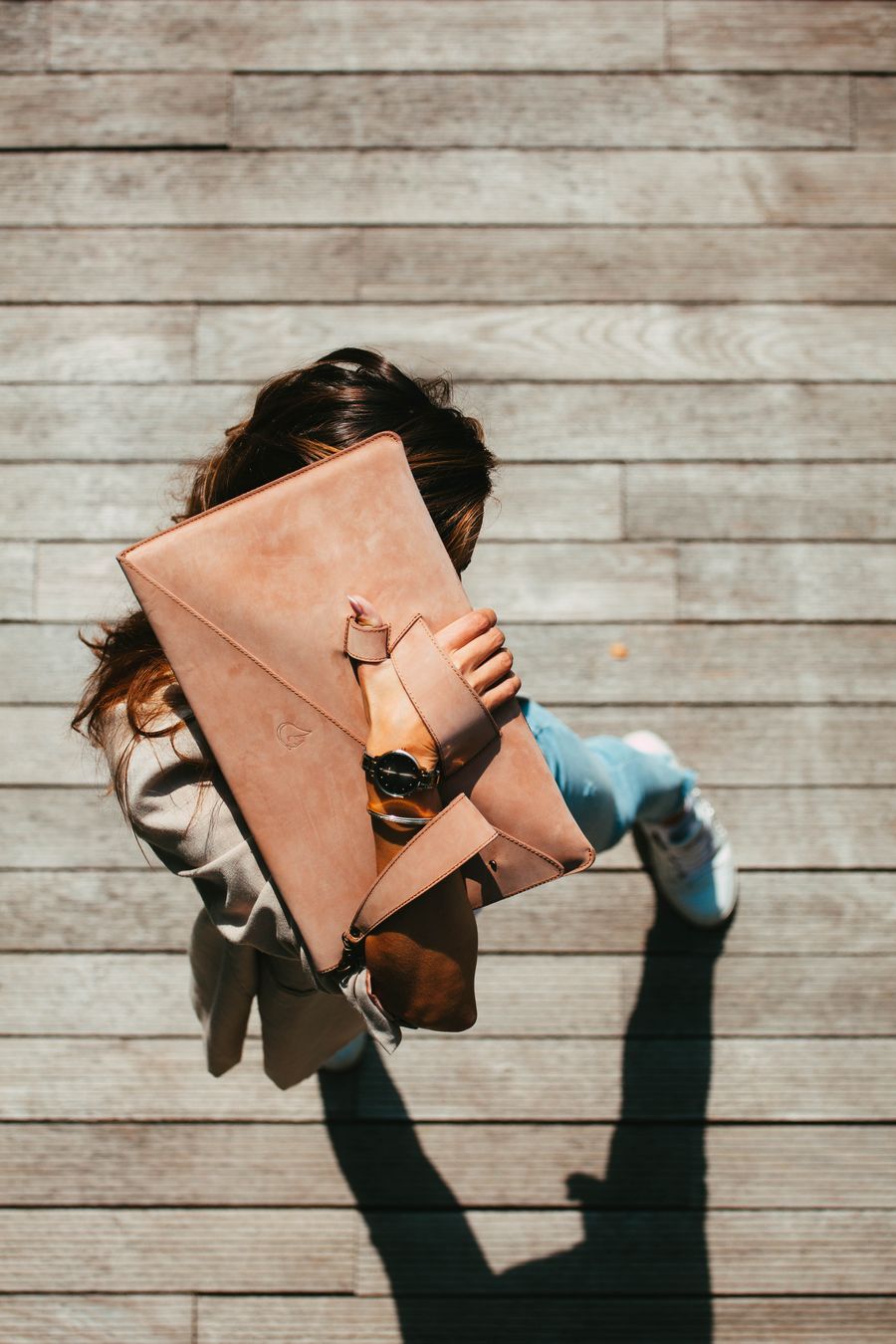 Woman carrying a large beige handbag