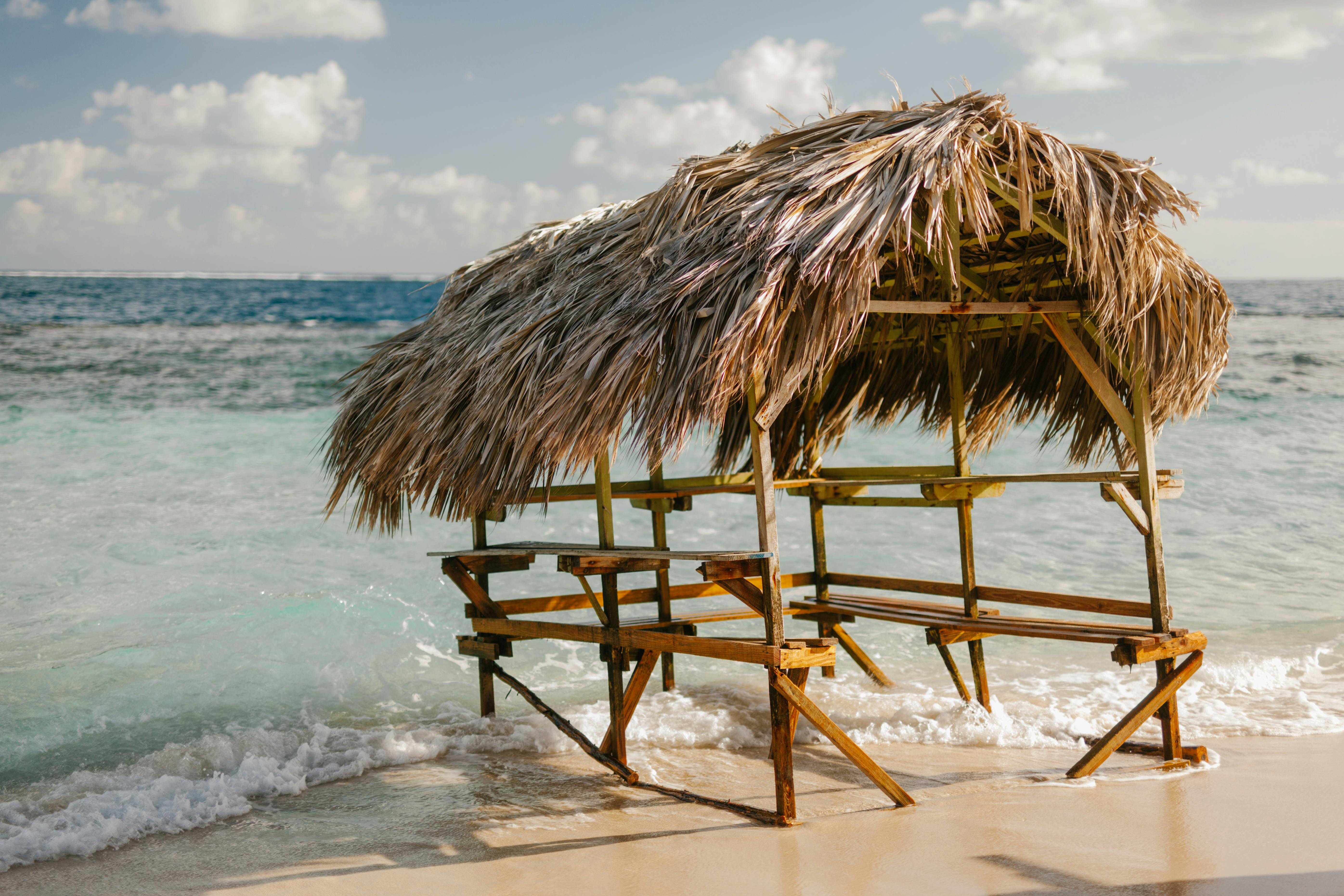 Cabaña De Madera Con Techo De Paja En La Playa De Arena · Foto de stock  gratuita