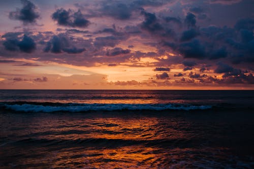 日没時の海の波の上の雲