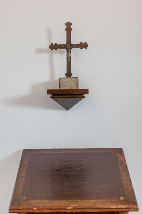 Old wooden pulpit with cross on wall