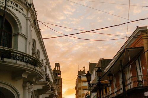Free From below of old stone house facades under colorful cloudy sky in city at sundown Stock Photo