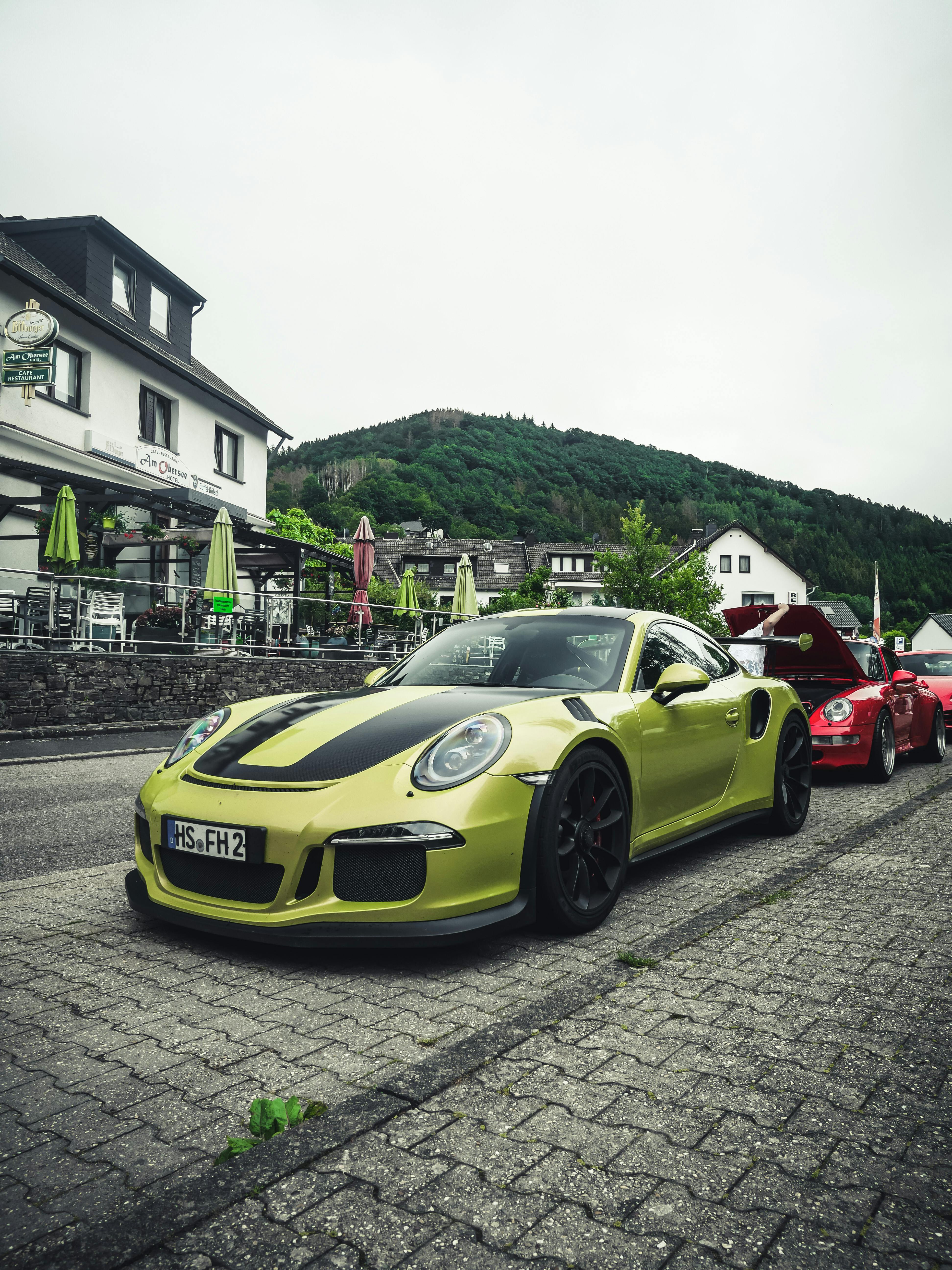 a green sports car parked on a concrete pavement