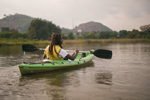 Femme En Jaune Et Noir Gilet De Sauvetage équitation Kayak Vert Sur La Rivière