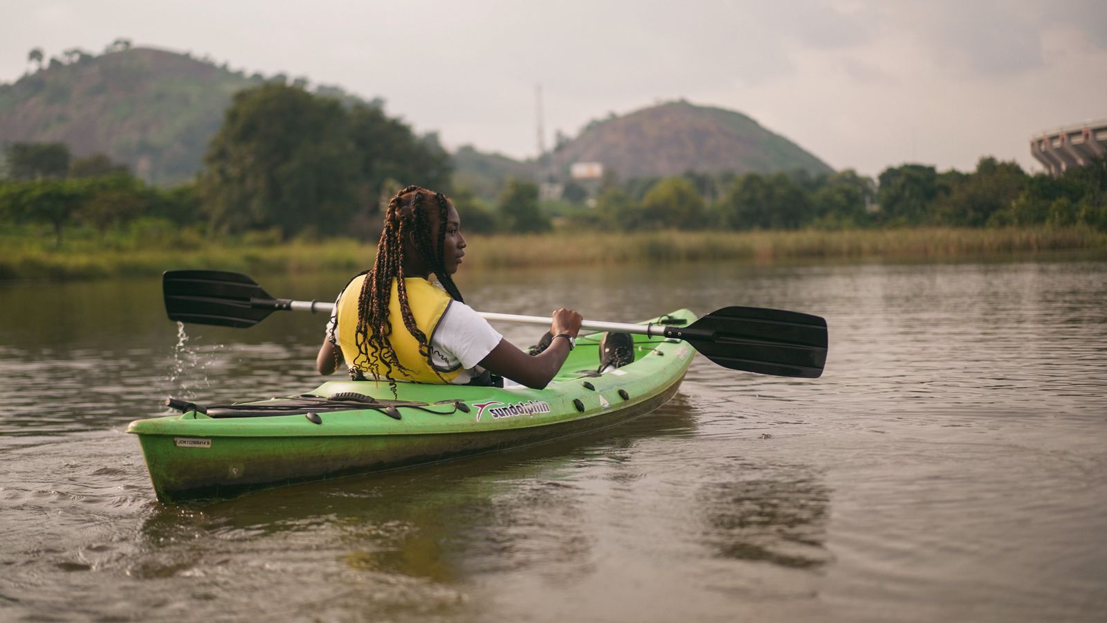 A woman riding a kayak on a lake, Nigeria