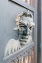 Stone mascaron on old gate with ornament