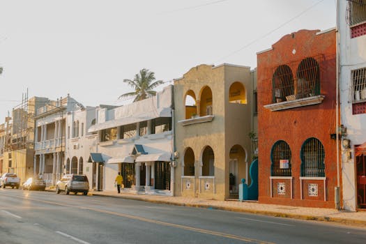 Aged masonry building exteriors with arches near asphalt roadway with automobiles in Egypt in sunlight