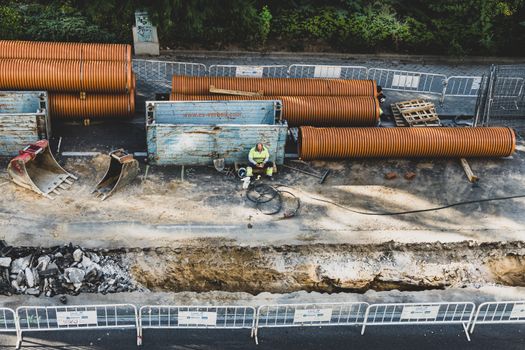 A construction worker takes a break at a site in Madrid, surrounded by equipment and materials.