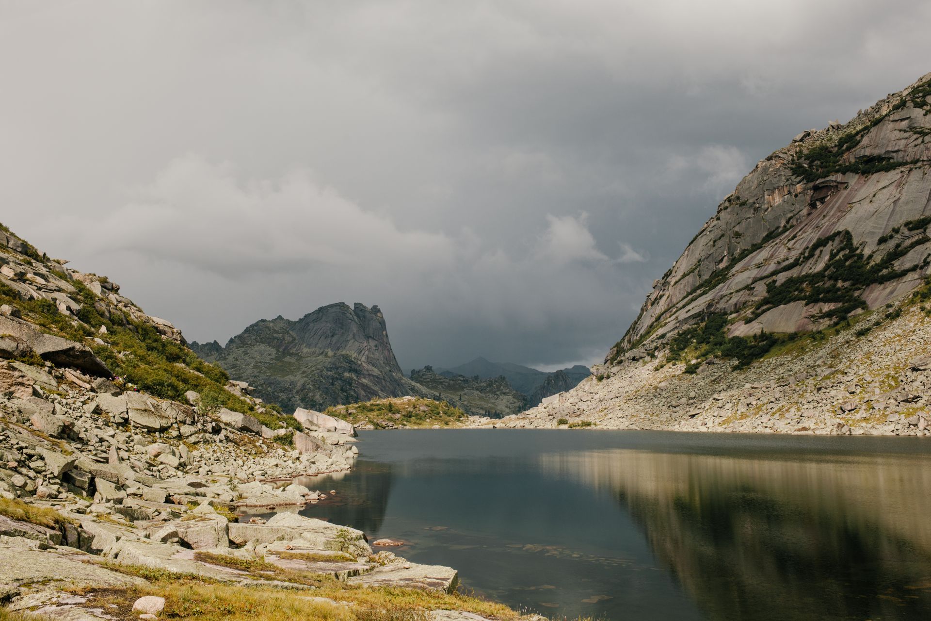 Tranquil mountain lake surrounded by rocky peaks in Khakassia, Russia.