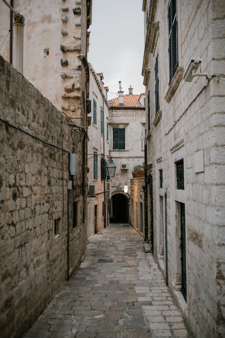 Narrow Cobblestone Street With Old Shabby Brick Buildings