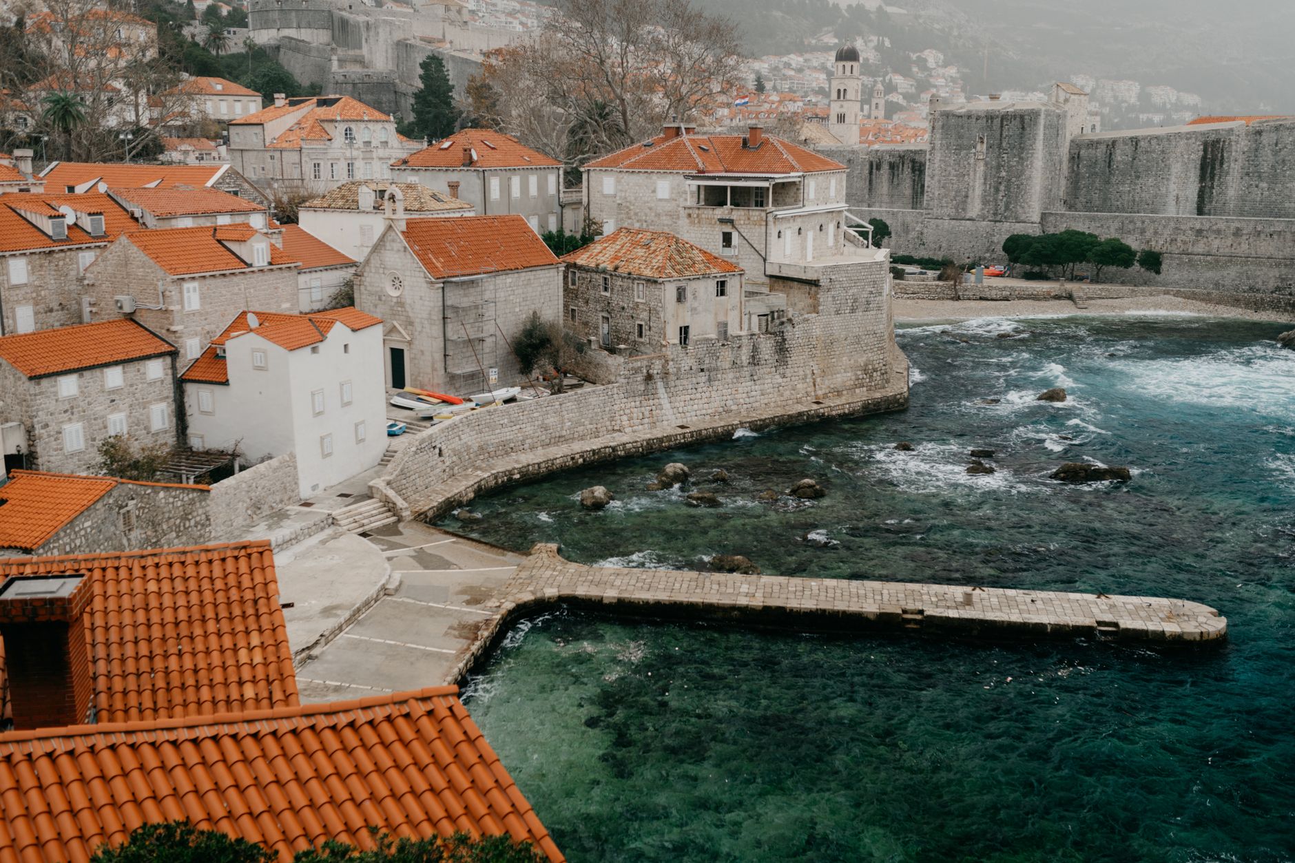 Autumn light on Dubrovnik Old Town rooftops in November with dramatic clouds behind Mount Srđ