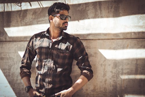 A Man in Casual Wear Posing by the Wall