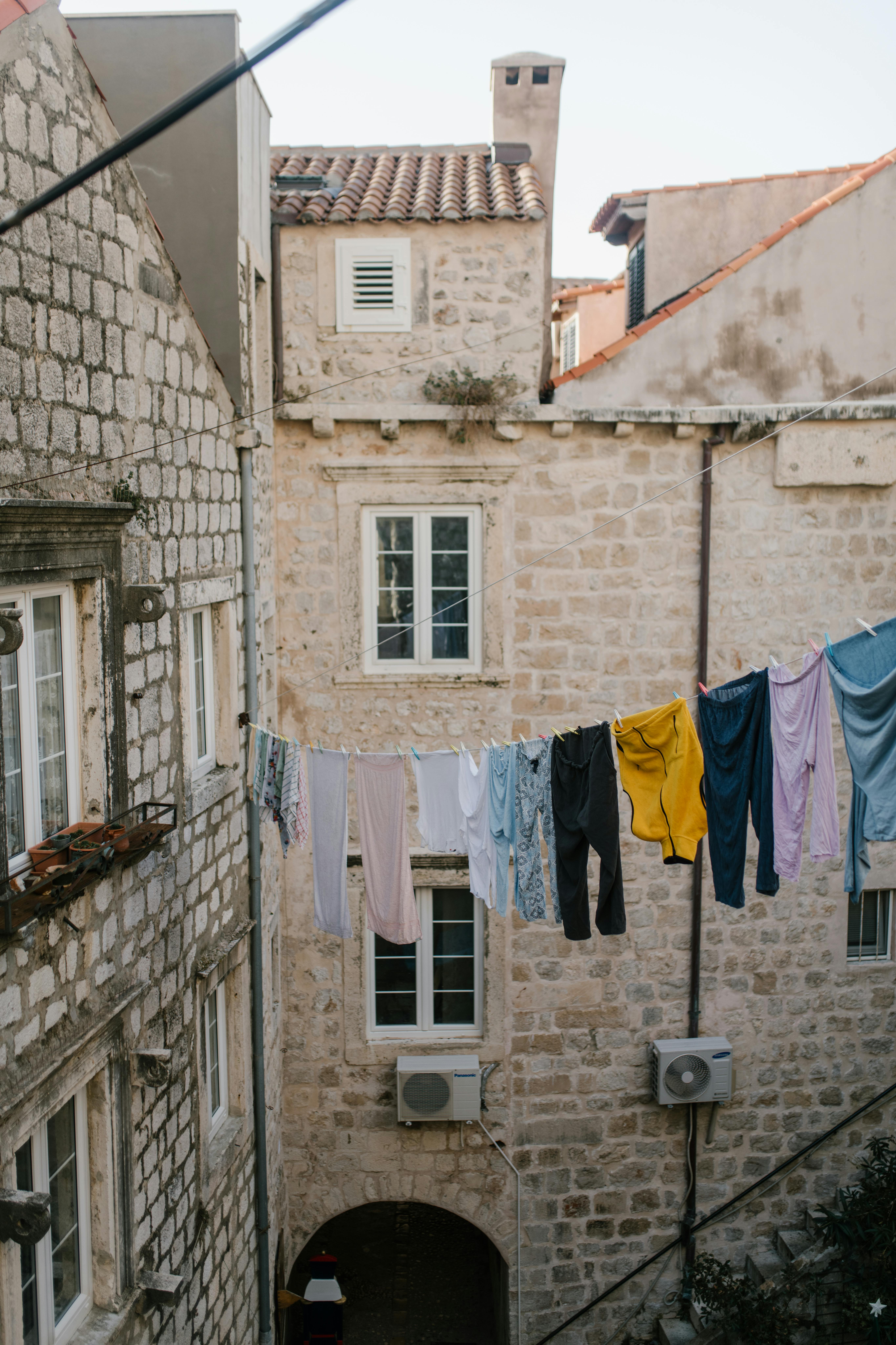 Clothesline between masonry buildings in city · Free Stock Photo