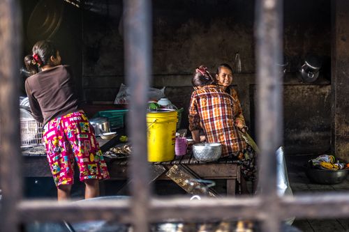 Free Women preparing food in a rustic Cambodian kitchen, showcasing traditional culinary practices. Stock Photo