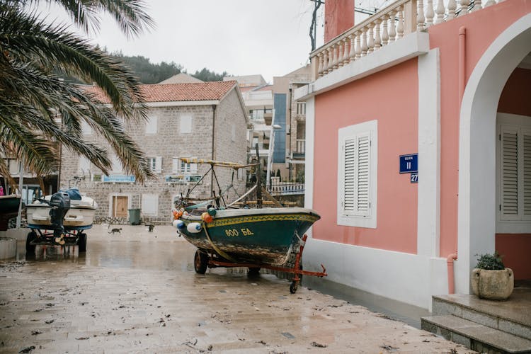 Motorboats On Cart Near Residential Building In Tropical Town