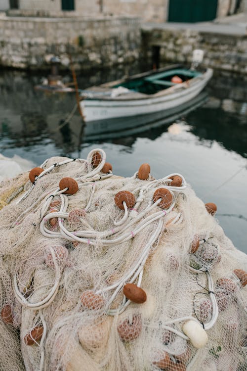 Free High angle of fishing nets with buoys tangled in heap placed on pier near boat Stock Photo
