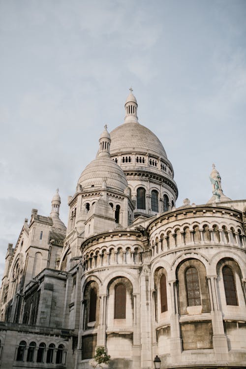 From below of famous historic building of Basilica of Sacre Coeur with high domes in Paris