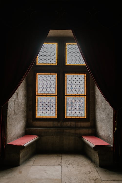 бесплатная Средневековая замковая комната с каменными скамейками у окна Стоковое фото